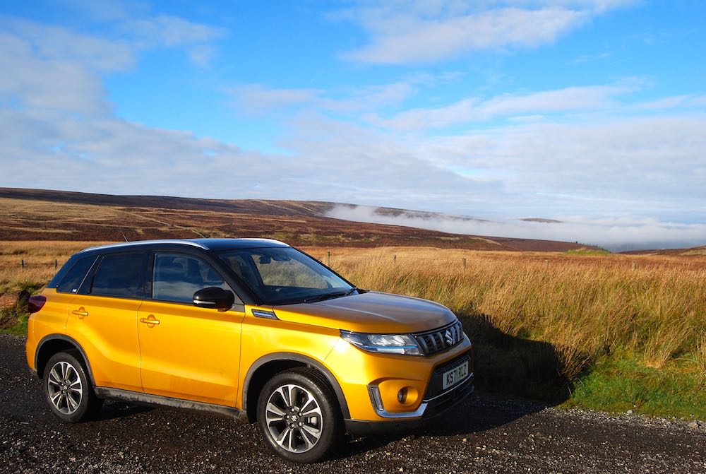 https://drivingtorque.com/wp-content/uploads/2023/01/2023-suzuki-vitara-orange-side-review-roadtest-off-road.jpg